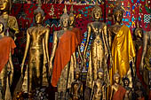 Wat Xieng Thong temple in Luang Prabang, Laos. standing Buddha statues in the  calling for rain  mudra with both arms down at sides and palms against thighs. Royal Funerary carriage hall. 